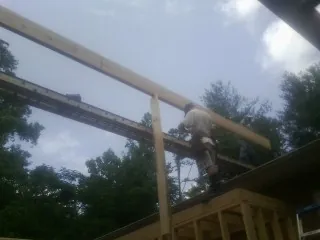 Carpenter setting a ridge beam over a new addition frame — Ice Dam Removal by Roofing Brothers in Herald