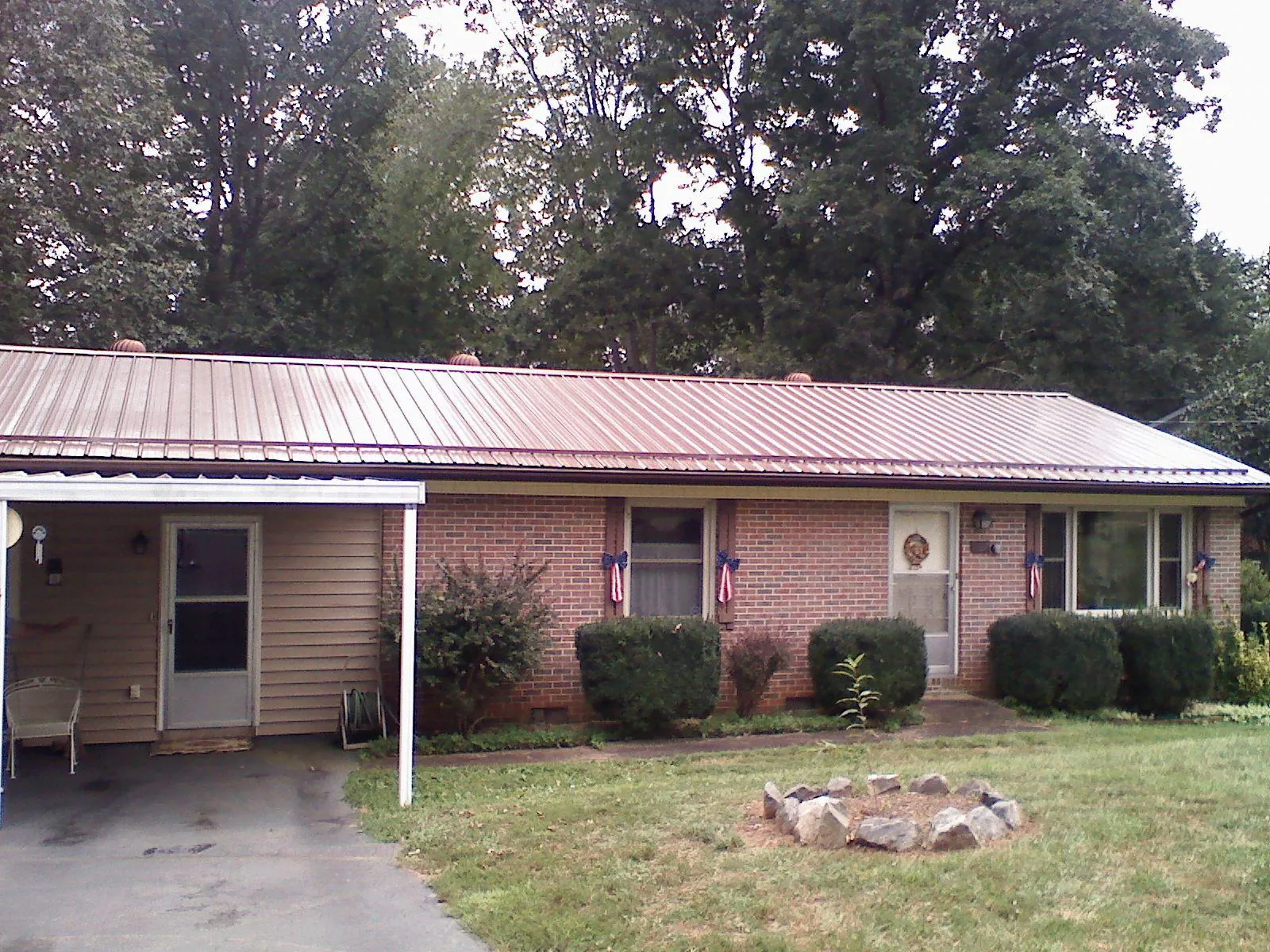 Bronze metal roof and carport on a brick ranch home — Roof Repair work by our crew in Herald