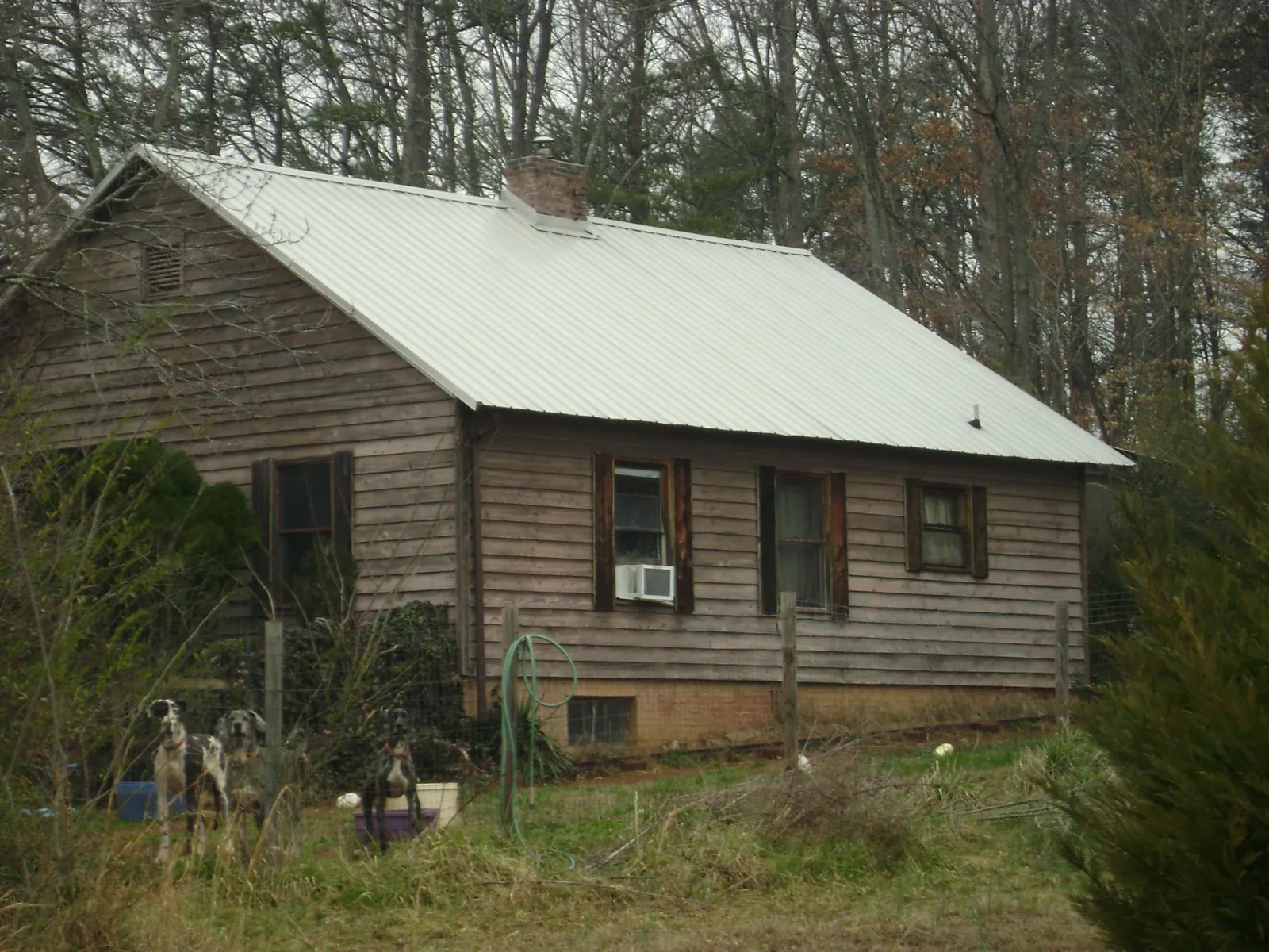 White metal roof on an old wood sided farmhouse, from a Metal Roof Installation job in Herald